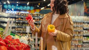 A shopper carefully selects produce at a grocery store
